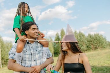 Joyful family enjoying quality time outdoors in summer with playful activities.